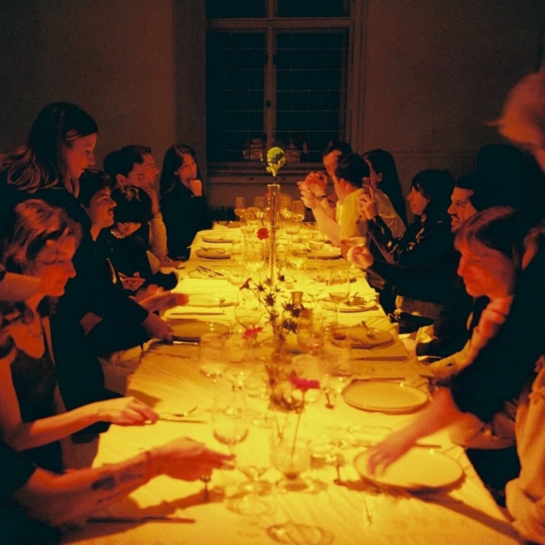 Guests along a long candlelit table at Mesaa 001